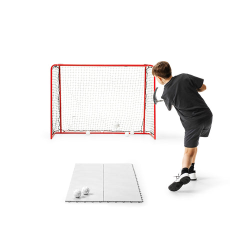Floorball player warming up with ball touches on a large floor tile area